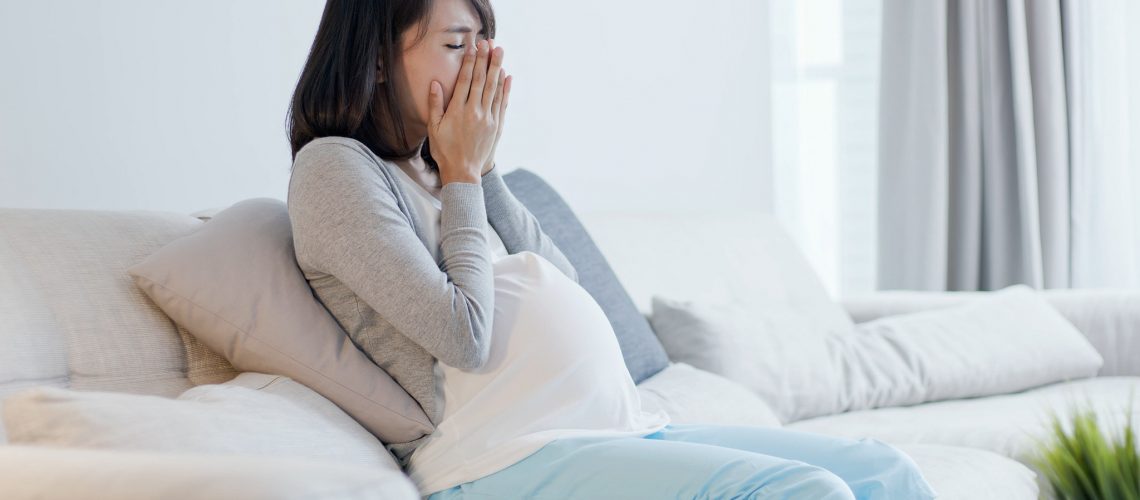 pregnant woman look smart phone and feel depression at home